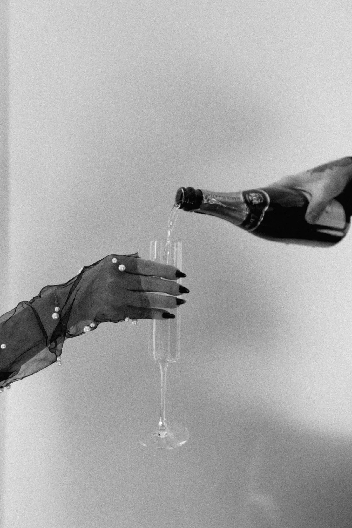 Champagne pour in pearl mesh glove, brand celebration detail