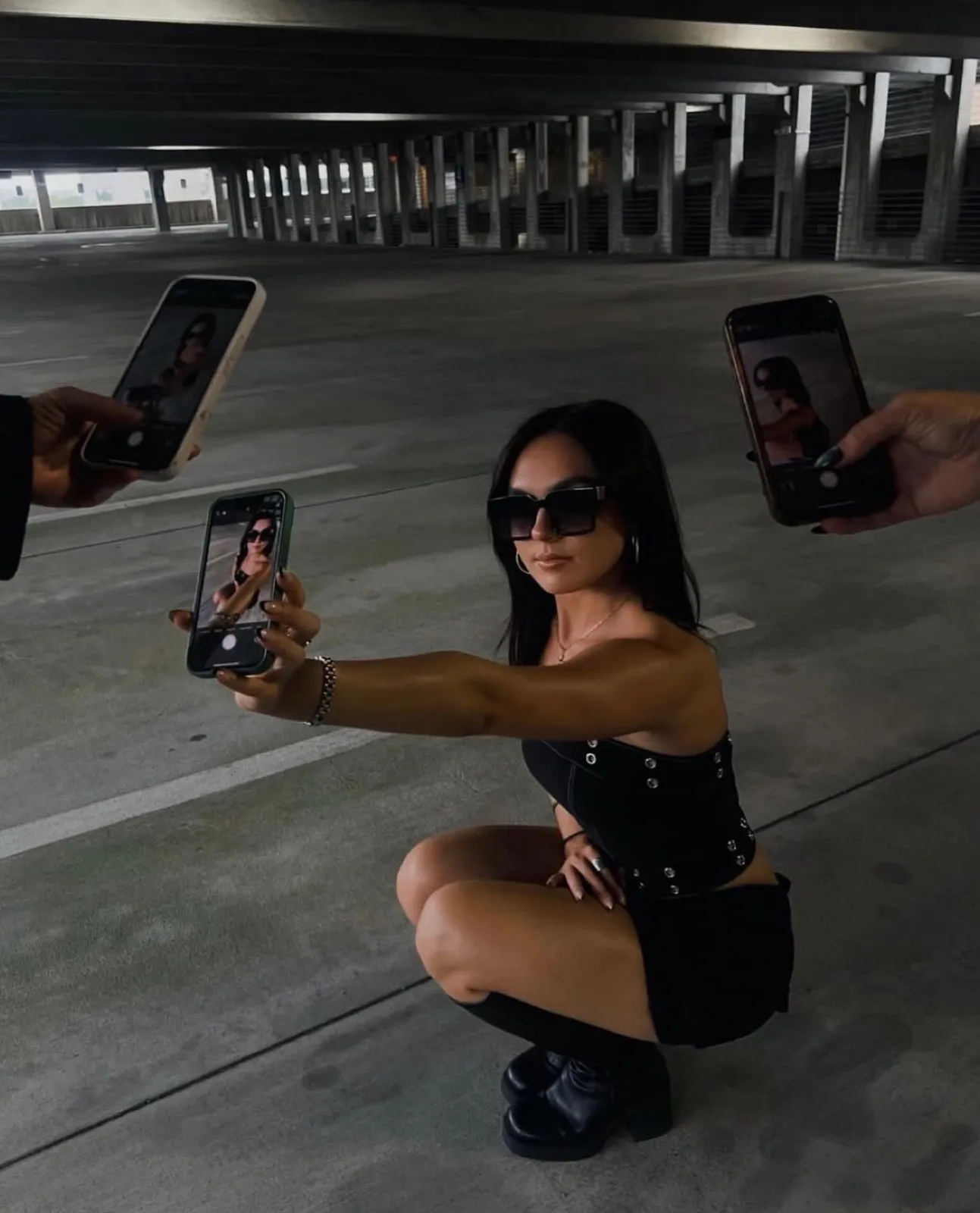 Editorial portrait framed by phones in a parking garage
