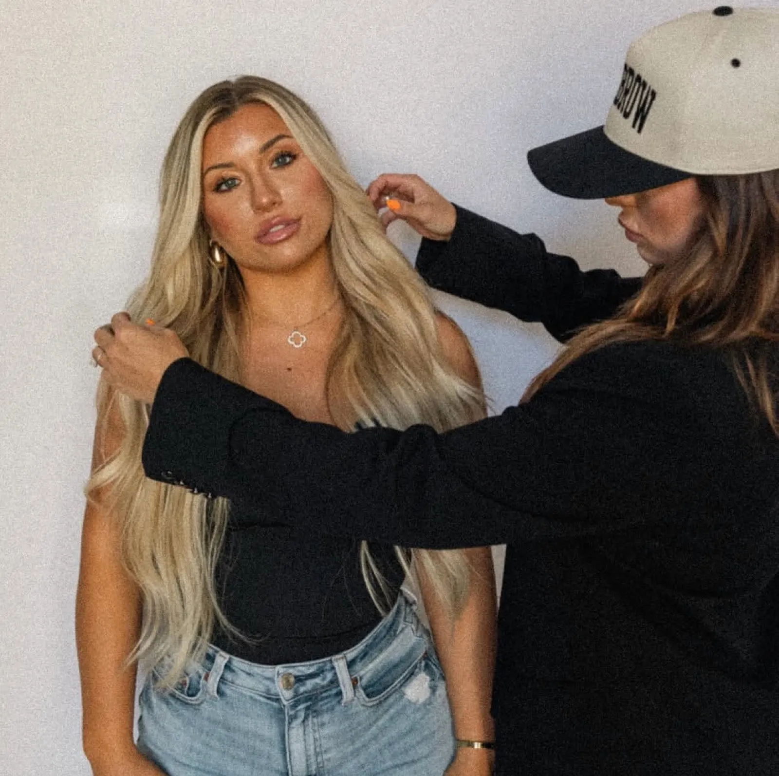 Stylist finishing long blonde waves during a session